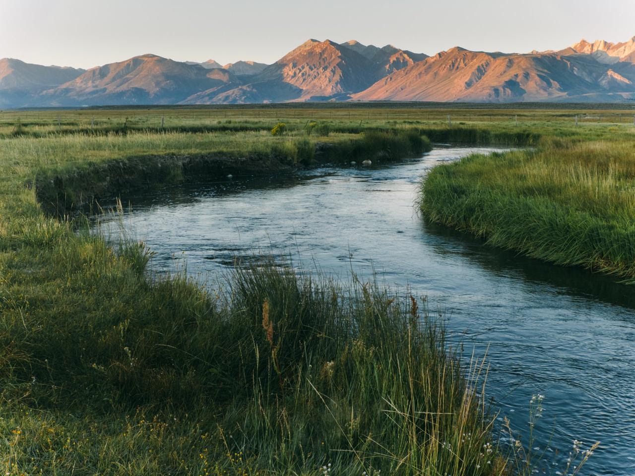 A mountain valley with a winding river at golden hour